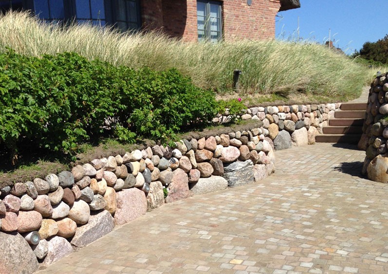 Einfahrt im Landhausstil mit Natursteinmauer